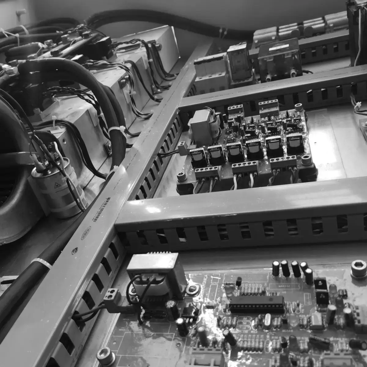 Inside the cabinet: transformer, centrifugal fan, capacitors and in-house control boards mounted on a backplate, with the wiring run in trunking.