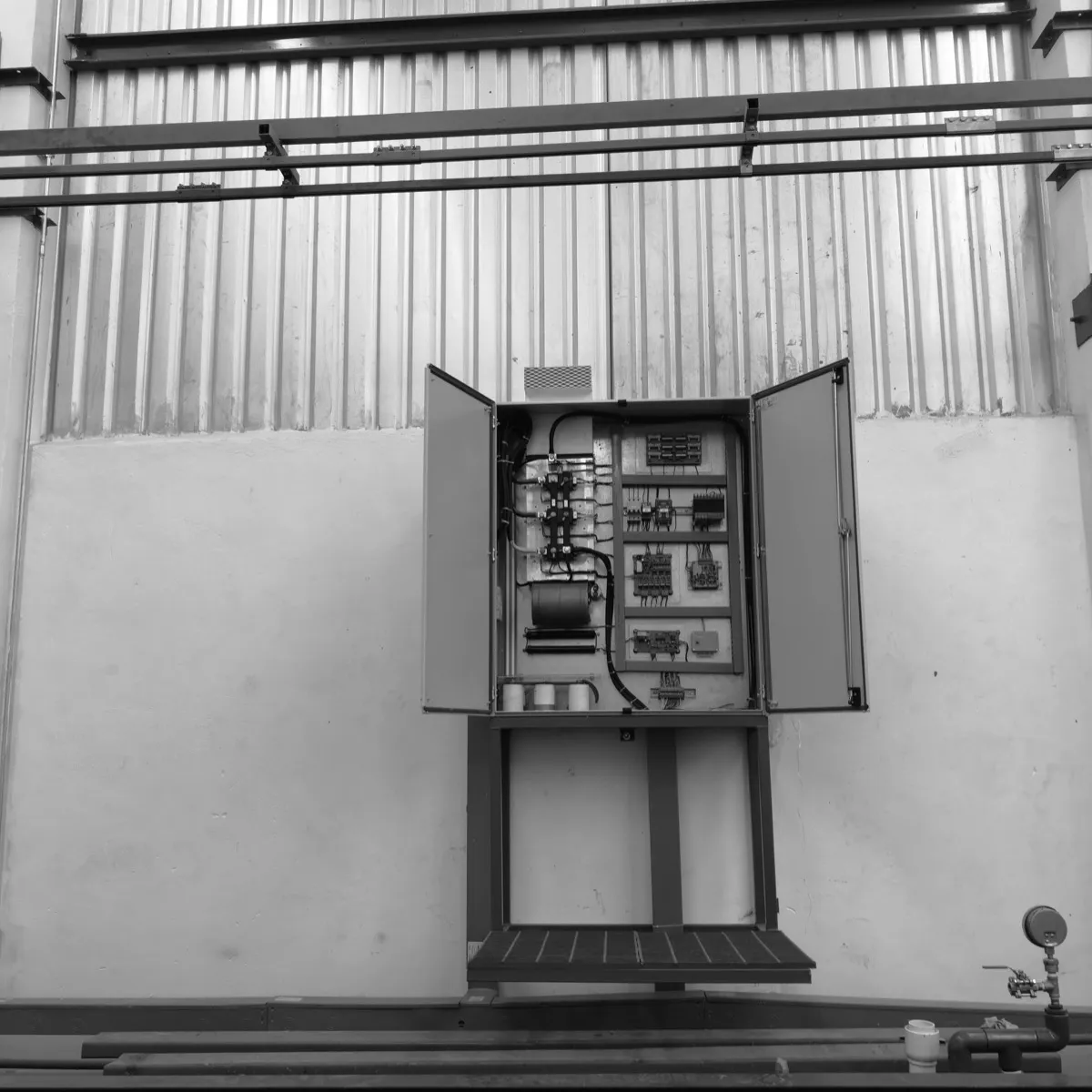 Open control panel, mounted on its base on a plant floor