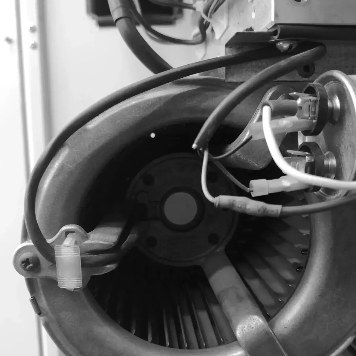 Centrifugal fan of the cabinet, with its supply wiring landed on terminals.